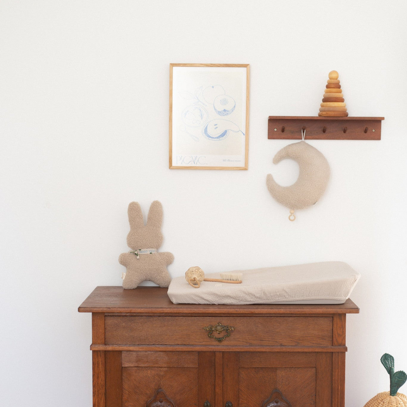 Commode met aankleedkussen, rammelaar en knuffel.
