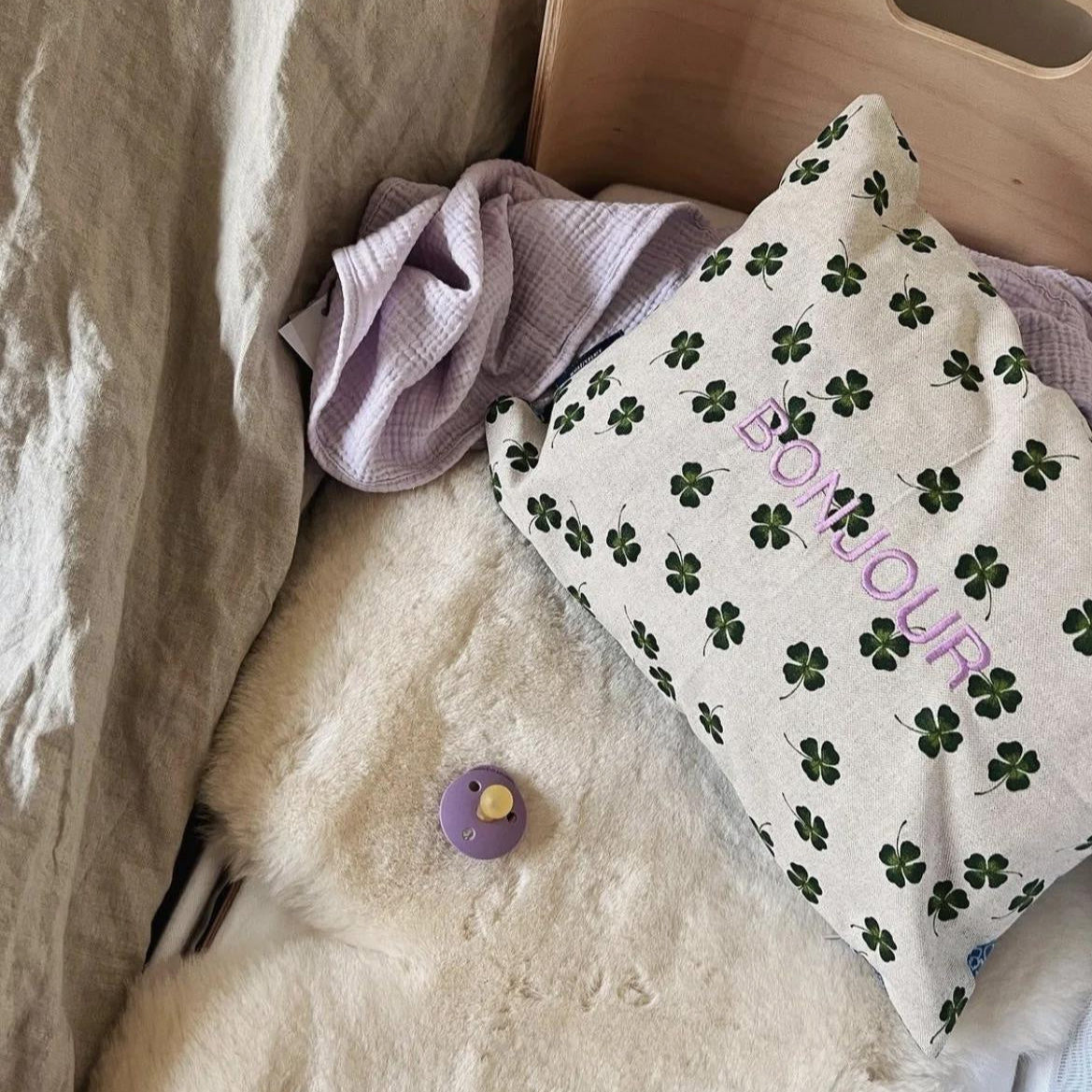co-sleeper met speen, hydrofiele doek en kussen met tekst.