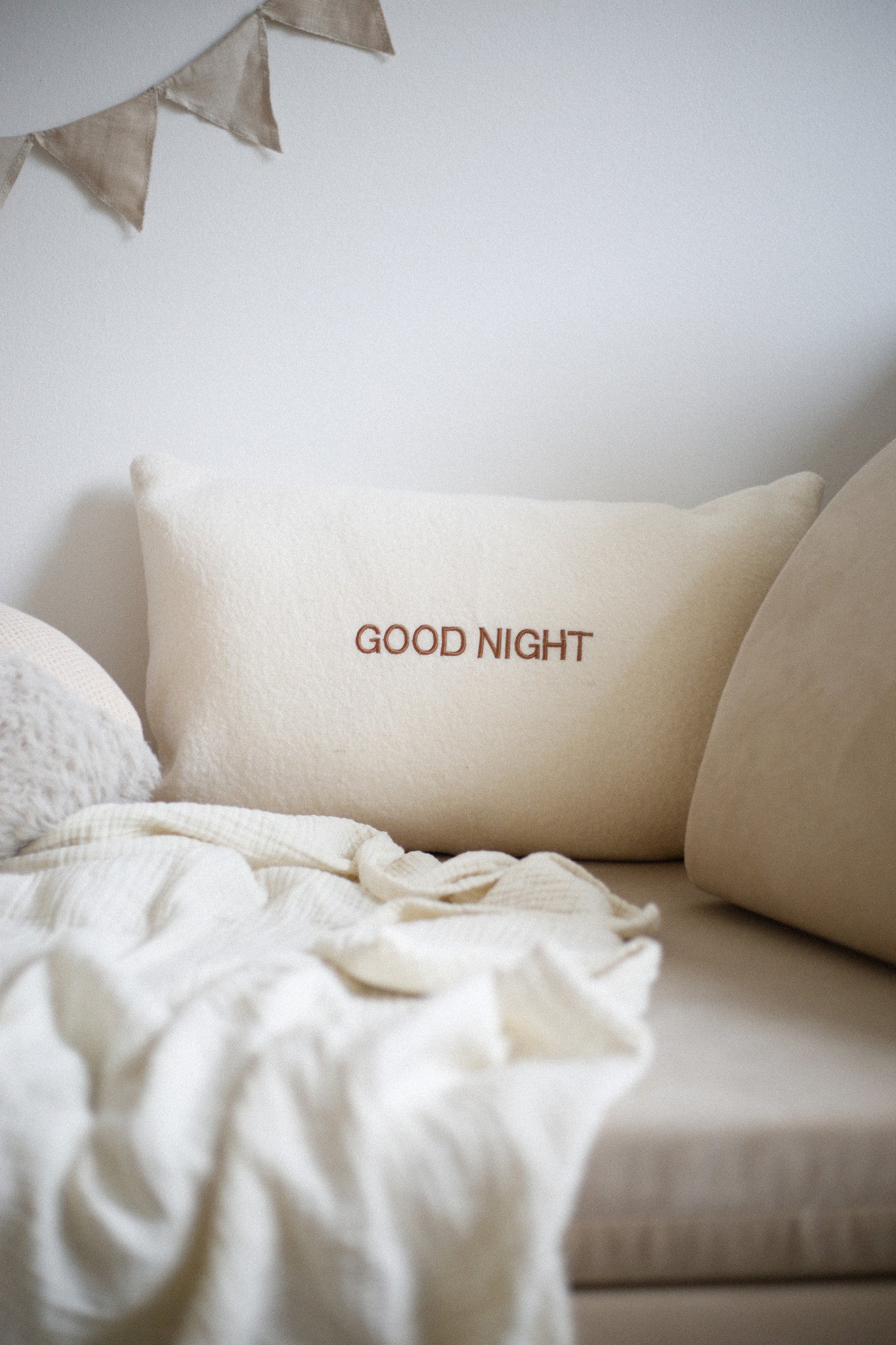 Zacht kussen van wol met een gepersonaliseerde tekst erop