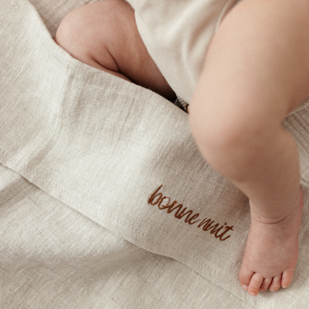 baby ligt onder laken met gepersonaliseerde tekst