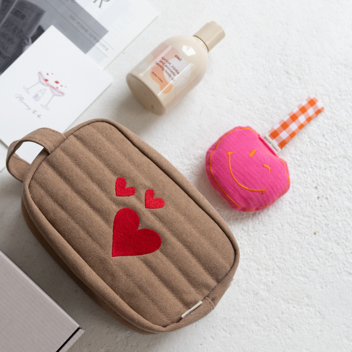 Giftbox met een gepersonaliseerde toilettas, speendoek, bodyolie en kaart