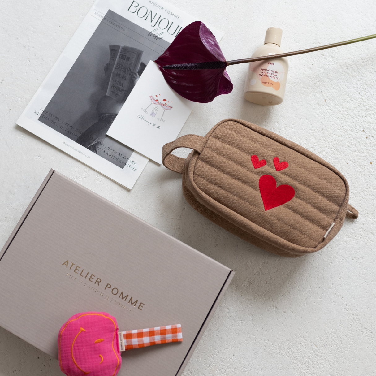 Giftbox met een gepersonaliseerde toilettas, speendoek, bodyolie en kaart