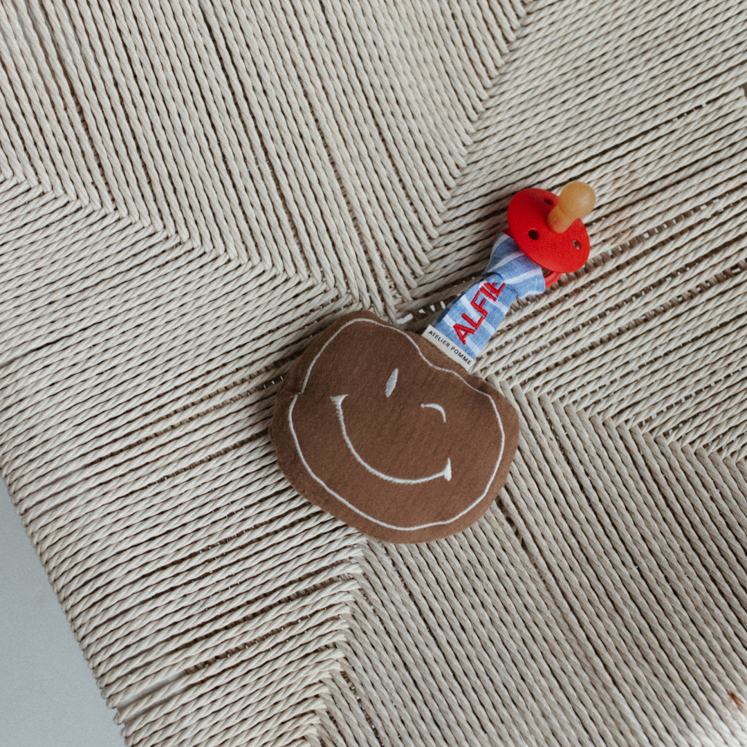 Een gepersonaliseerd speendoekje met de naam erop in het bruin