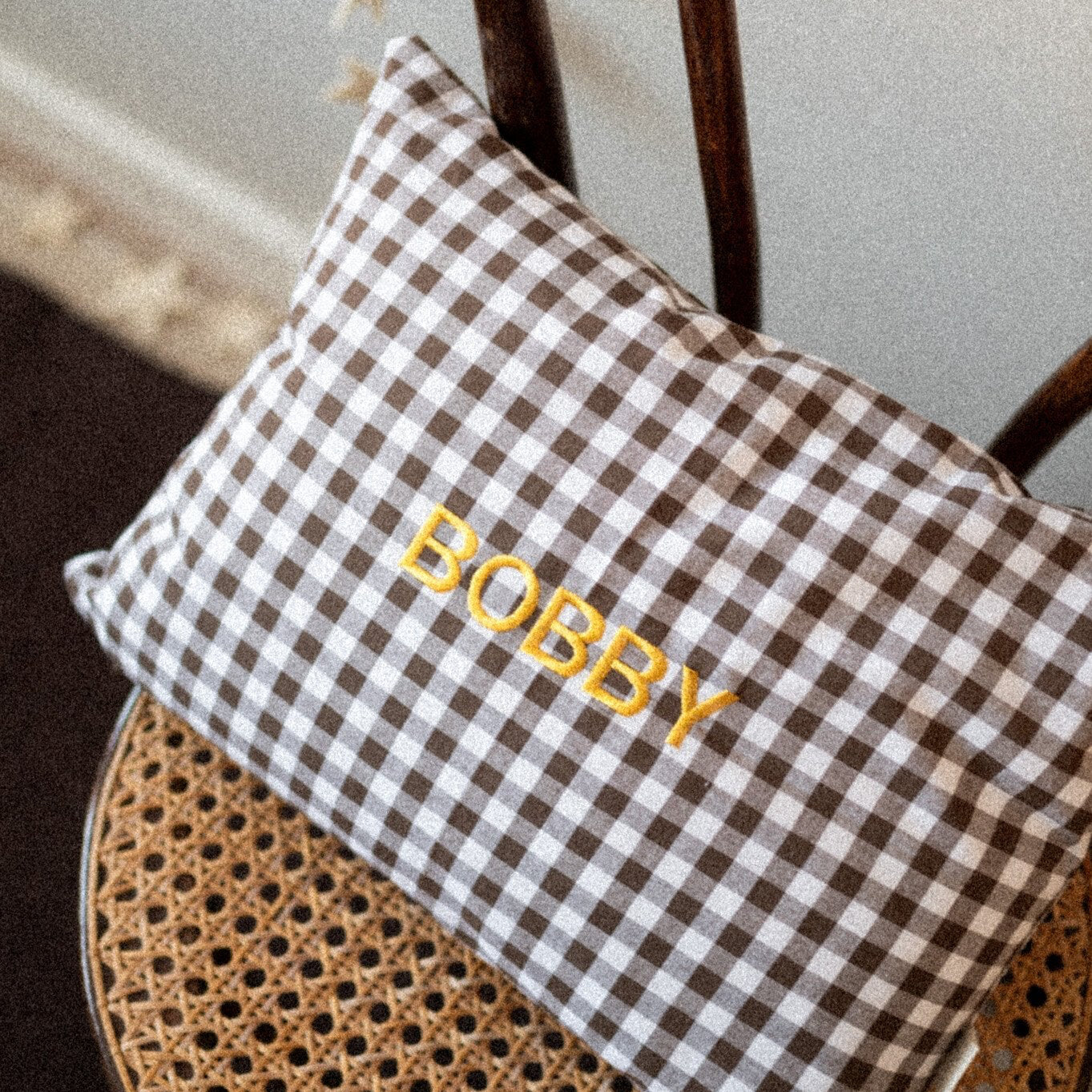 kussen met blokjes in het bruin met wit en naam erop geborduurd