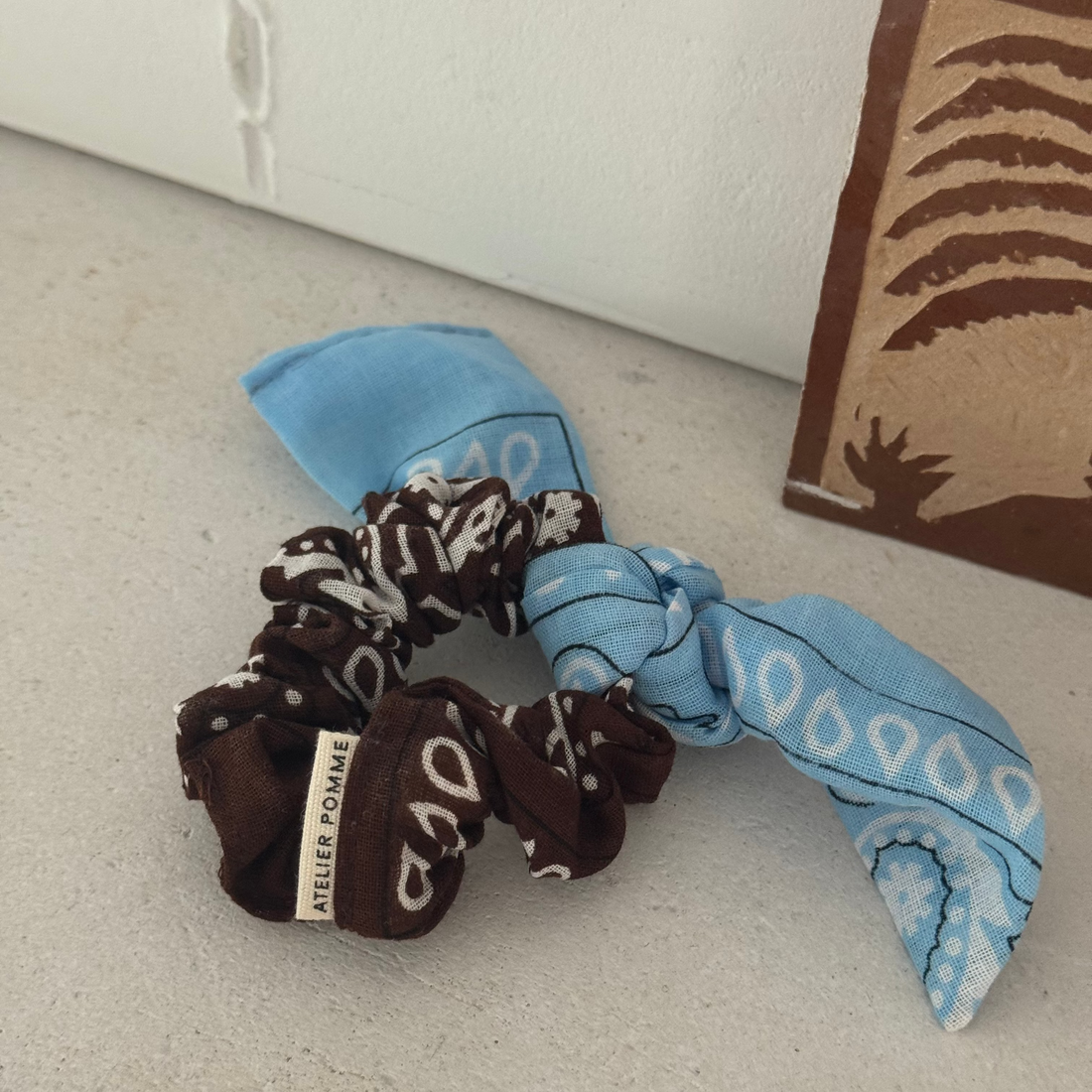 Een bruine met blauwe bandana scrunchie 