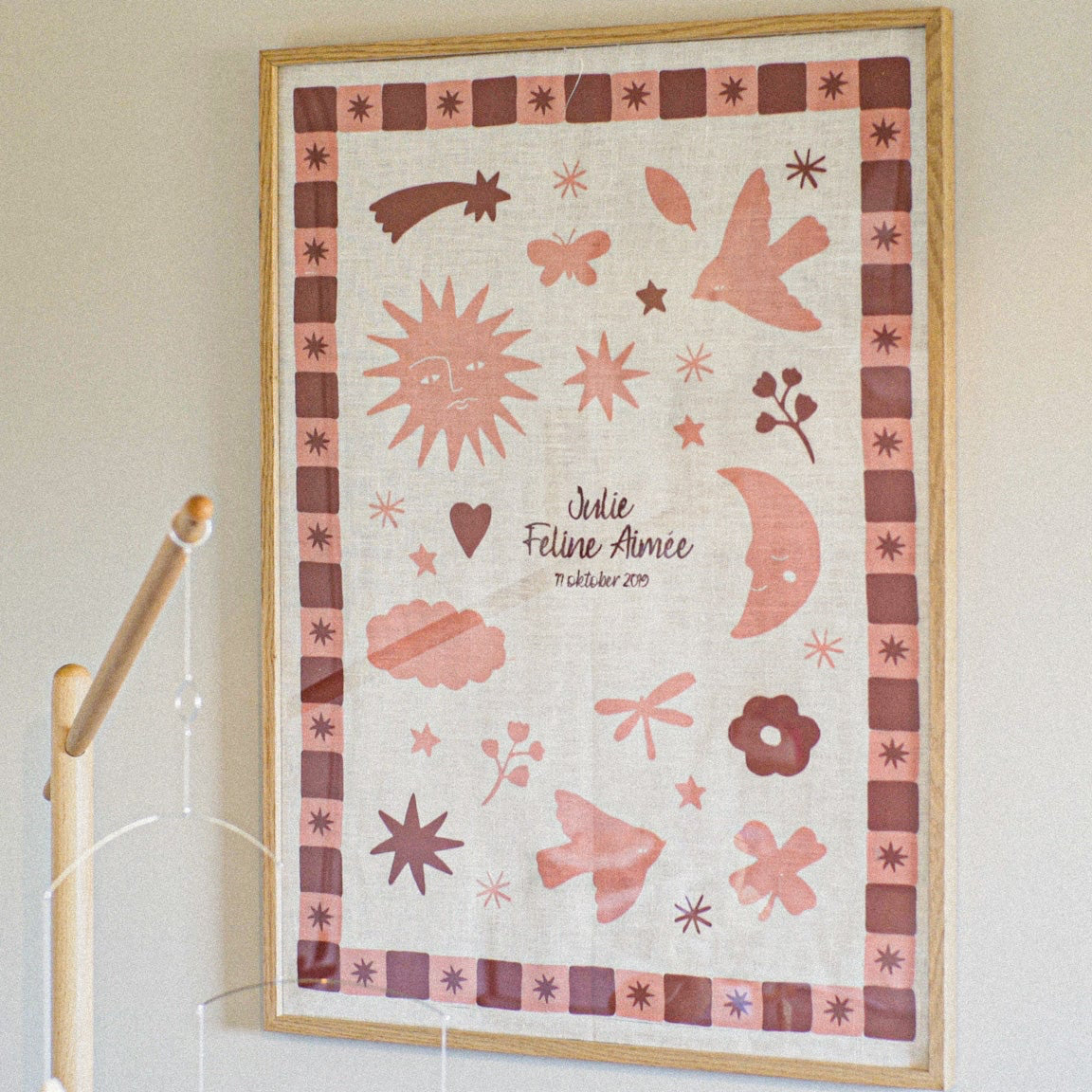 Geboorte poster in roze hangend aan de muur 