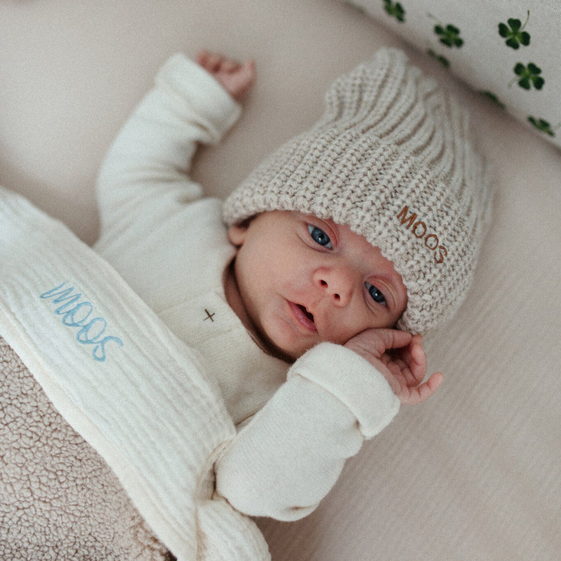 baby ligt onder laken met tekst. 