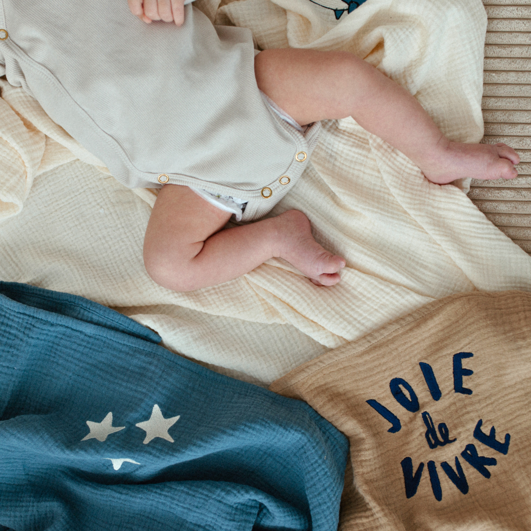 baby ligt op meerdere lakens met iconen erop. 