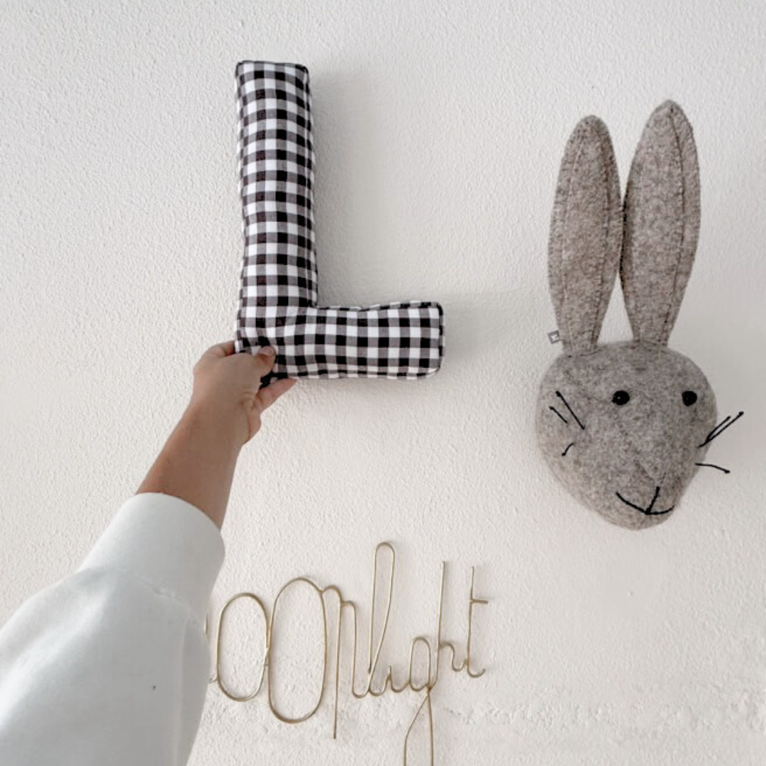 Een geruit letter voor aan de muur 