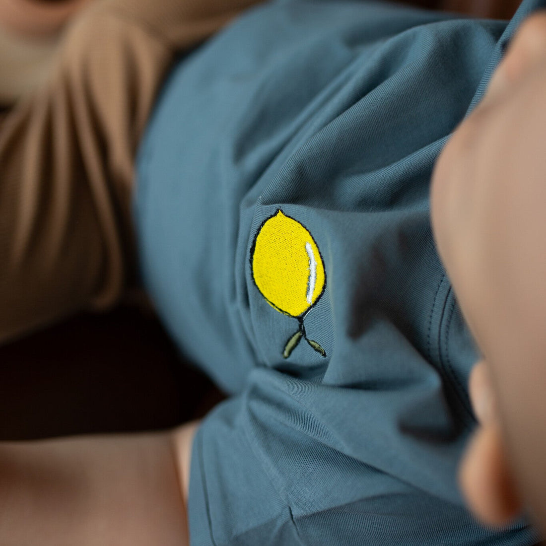 baby heeft blauw T-shirt met icoon aan. 