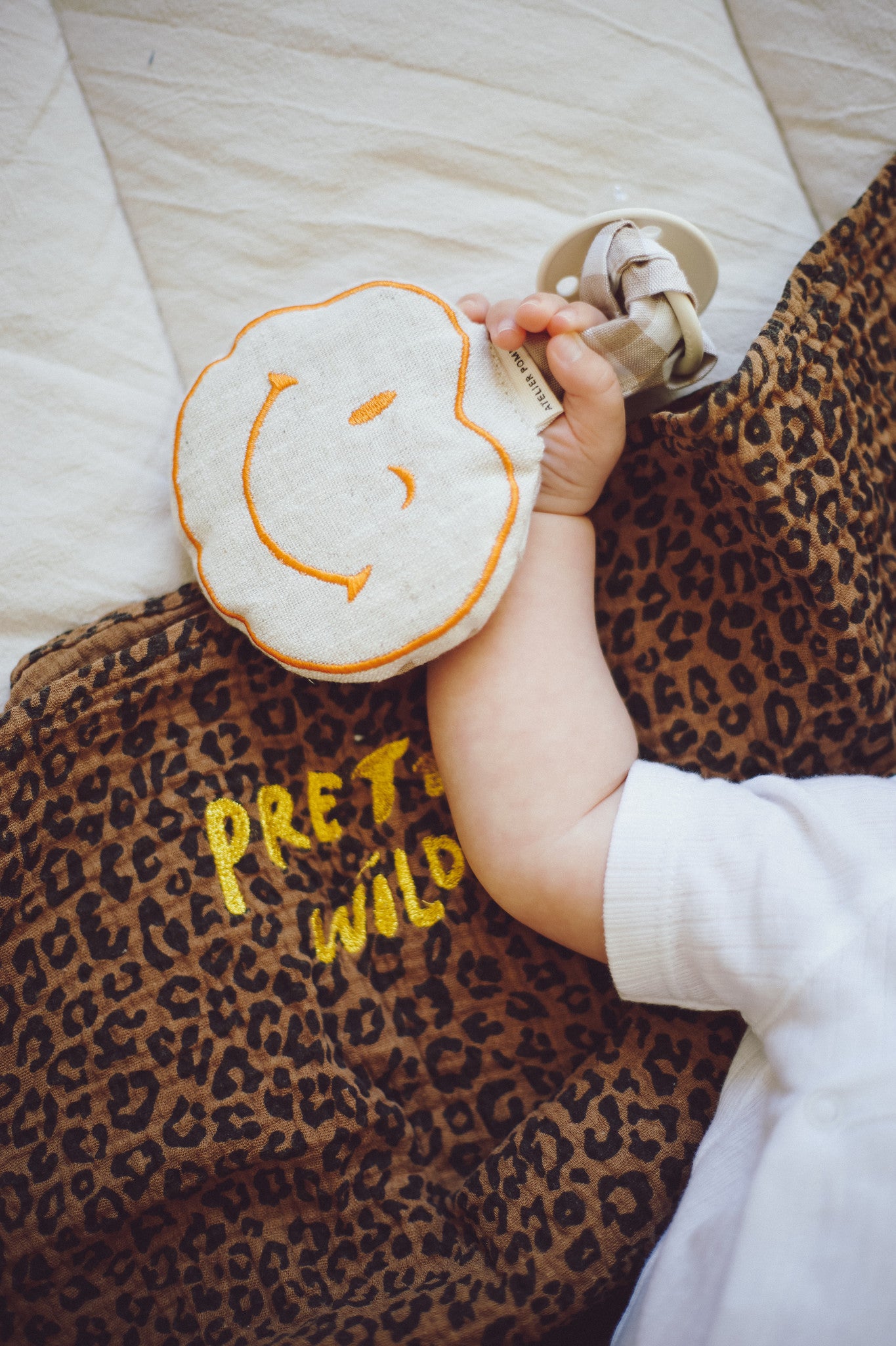 baby met beige speen en speenkoord
